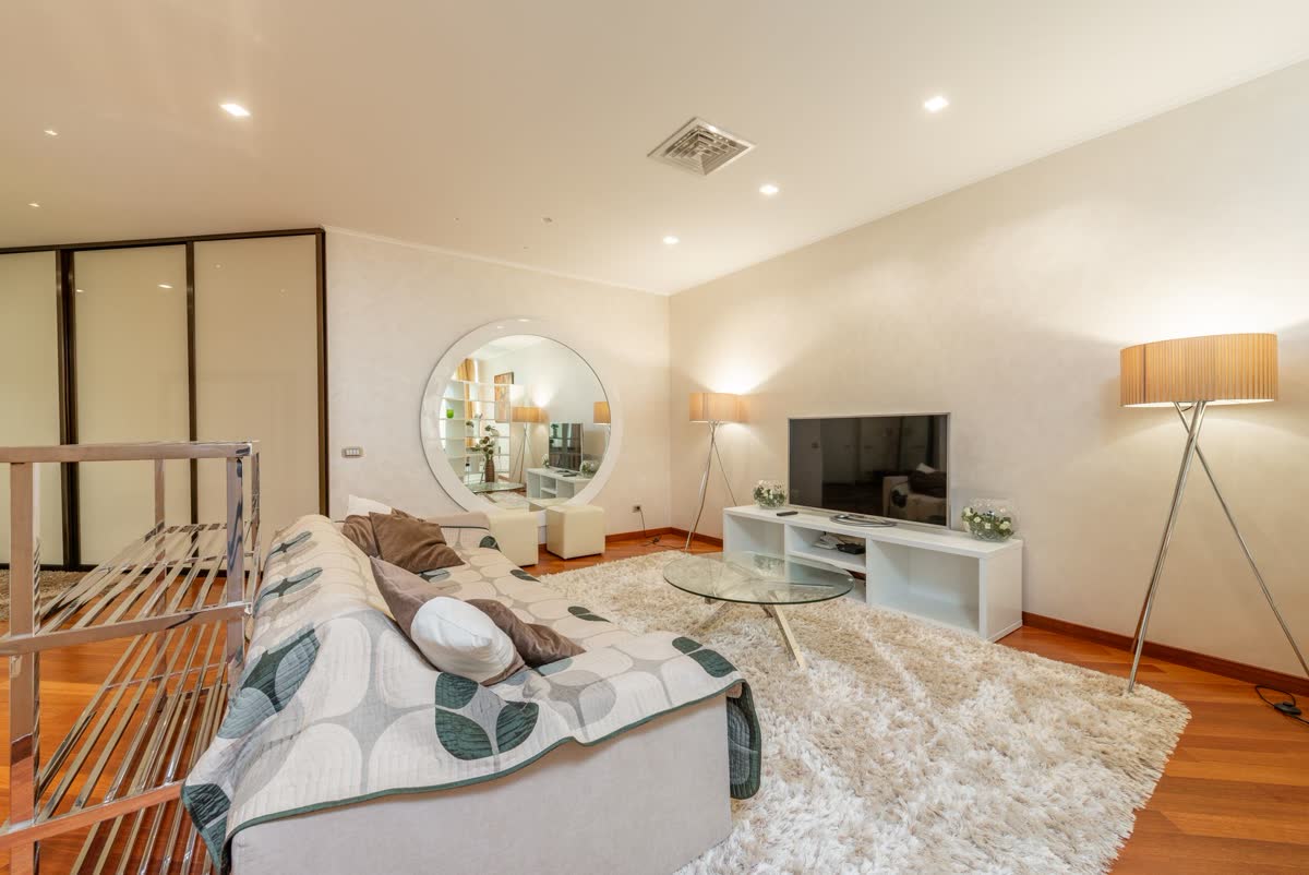 A cozy living room with a floor lamp and a rug