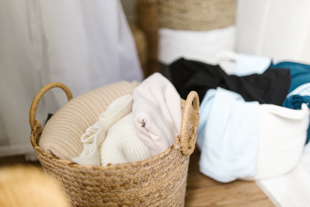 A woven laundry basket with folded clothes