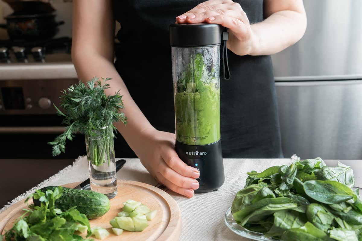 A personal blender with greens for a smoothie