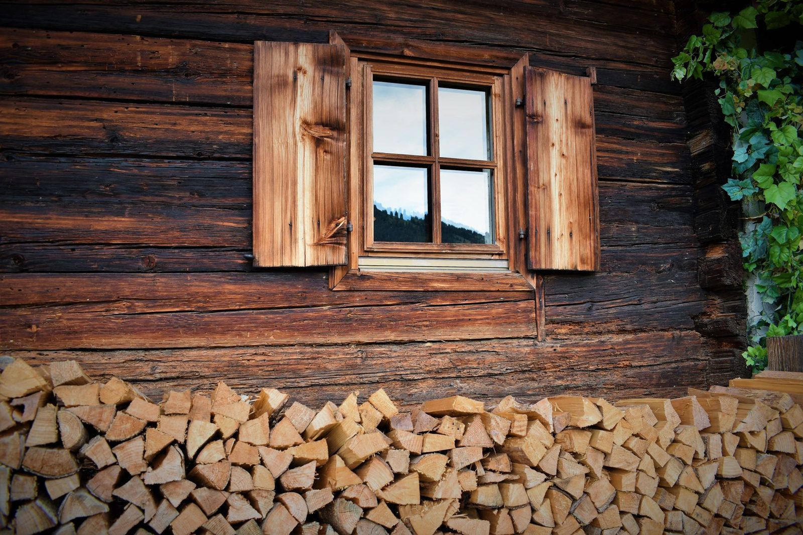 Firewood stacked neatly beneath a cabin window
