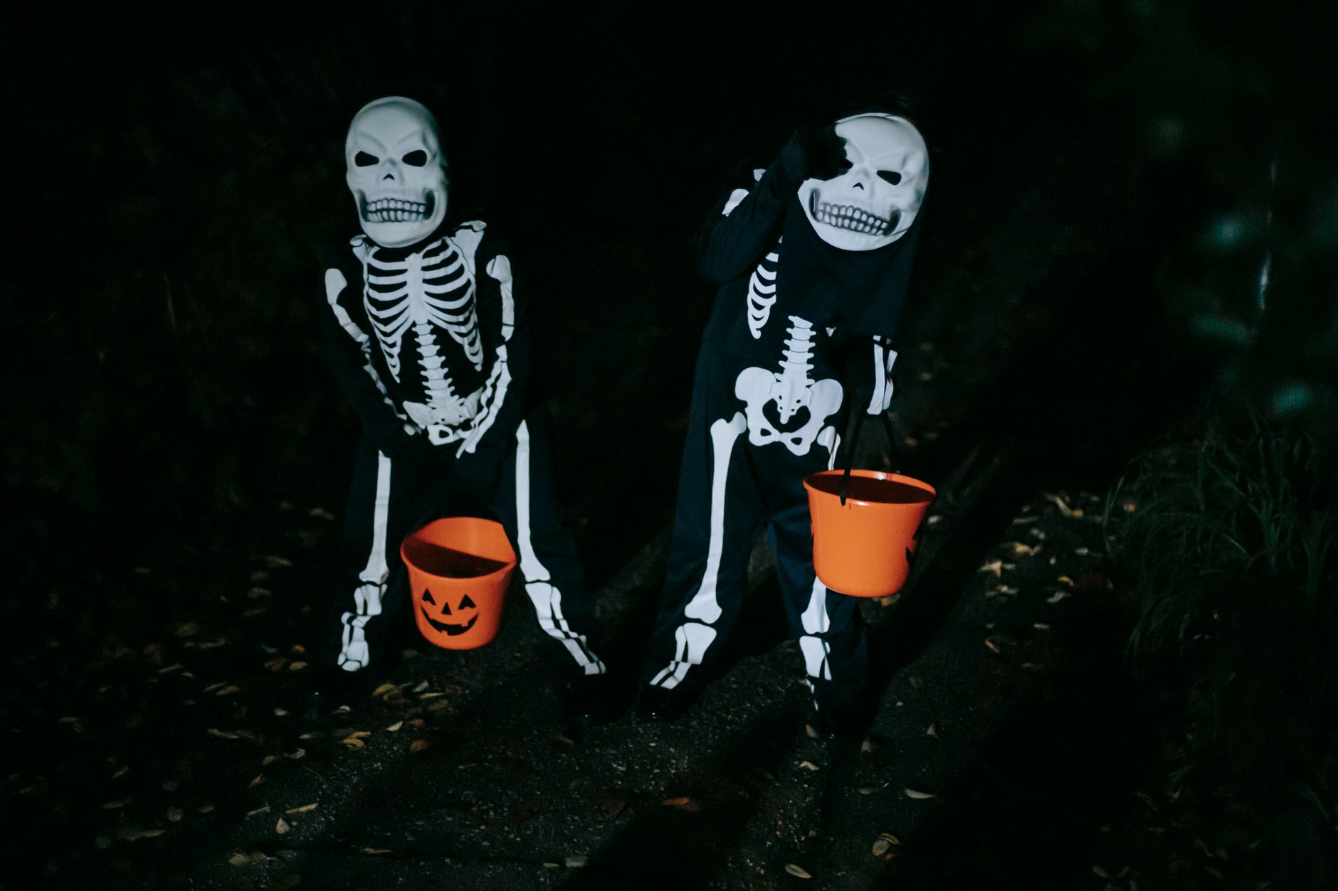 Two kids in bright red and witch costumes smiling