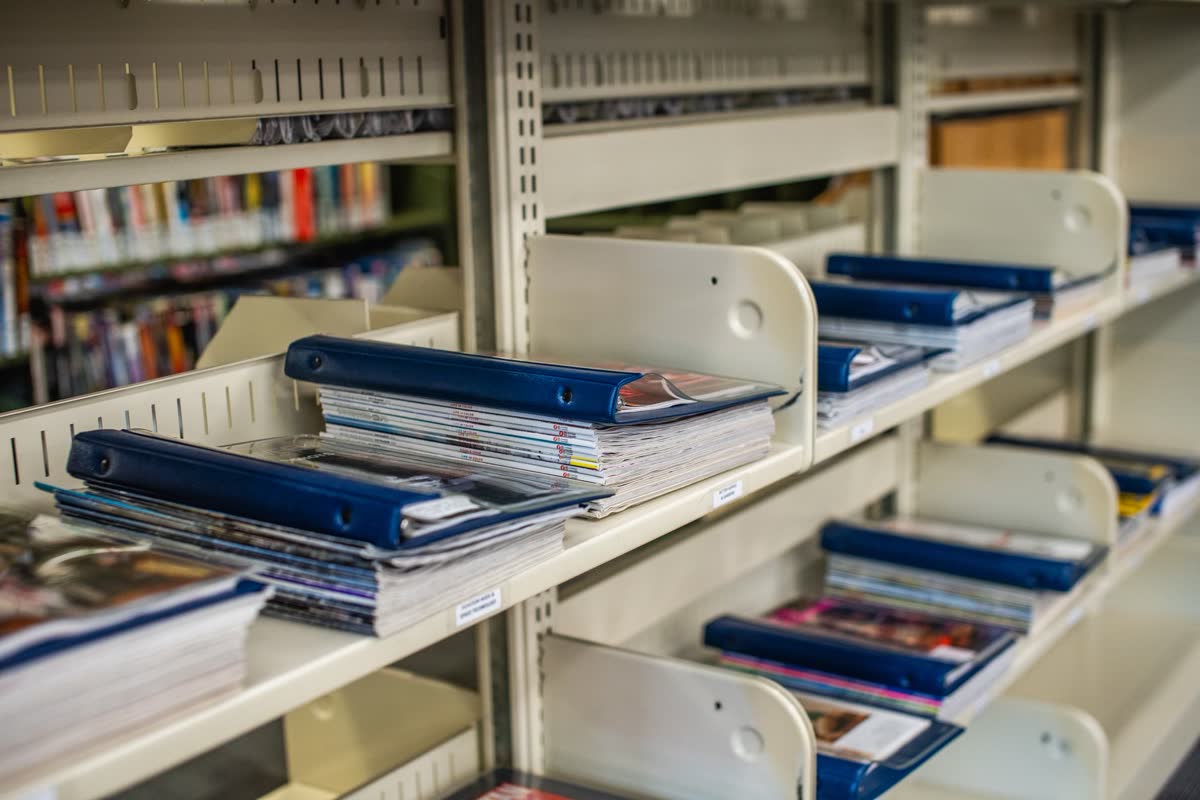 A shelf holding folders and books
