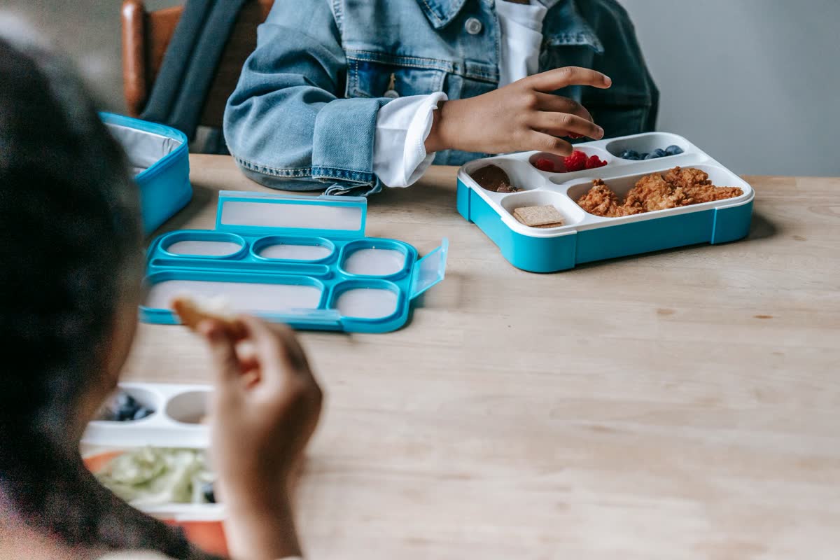Kids at a table with bento-style lunch boxes